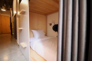 a bedroom with a white bed and a curtain at Triver Coliving in Mexico City