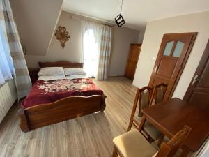 a bedroom with a bed and a table and a window at Domek pod lasem in Białka Tatrzanska +24 photos