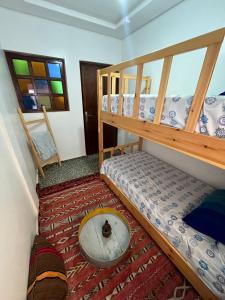 塔哈佐特Jada surf house taghazout的有两张双层床和一张桌子的房间 更多42张照片