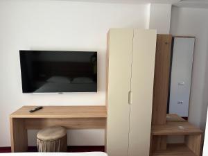 a room with a tv and a desk with a cabinet at Mimi Hotel in Corabia