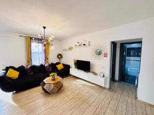 a living room with a black couch and a table at Gruenwald Paradis Sibiu in Şelimbăr