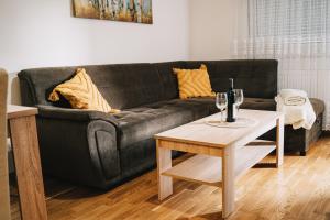 a living room with a black couch and a table at Apartman Valerija in Doboj
