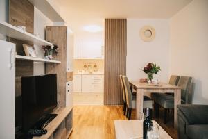 a living room with a dining room table and a kitchen at Apartman Valerija in Doboj