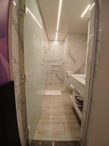 Un baño con ducha a ras de suelo y lavabo. en Vem Para o - Motel Marselha 2, en São Paulo