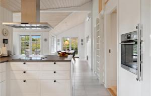 a kitchen with white cabinets and a hallway at Awesome Home In Græsted With Wifi in Græsted
