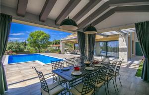 une salle à manger avec une table et des chaises et une piscine dans l'établissement Villa Verde, à Sveti Lovreč Pazenatički
