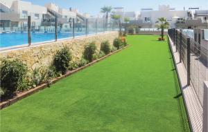 ein Balkon mit grünem Gras neben einem Swimmingpool in der Unterkunft 2 Bedroom Cozy Apartment In Torrevieja in Torrevieja