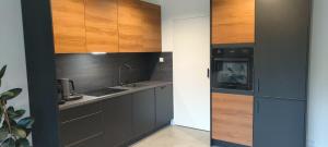 a kitchen with wooden cabinets and a sink at Wilga HOUSE in Piła