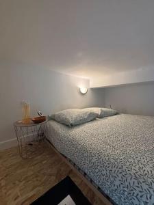 a bedroom with a bed and a side table at Studio industriel, mezzanine, rénové, central 201 in Saint-Étienne