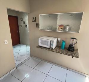 a kitchen with a microwave on a counter at Casa privativa próximo ao centro e aeroporto. in Campo Grande