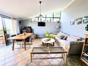 a living room with a couch and a table at Sea La Vie Beach House in Wilderness