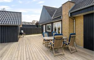 HesselagerにあるTwo-Bedroom Holiday Home In Hesselagerの木製デッキ(テーブル、椅子付)
