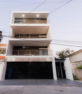 een groot wit gebouw met een zwarte garage bij Apartamentos Torre II Condominios - Pet Friendly in Mazatlán