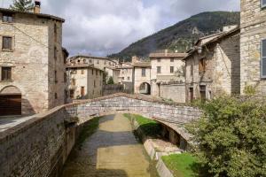 a stone bridge over a river in a city at Dimora Giada & Gloria in Gubbio