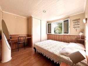 ein Schlafzimmer mit Bett, Schreibtisch und Fenster in der Unterkunft Maison Marina Pietra avec Jardin in Pietracorbara