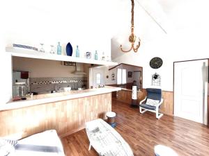 eine Küche mit einer Theke und Stühlen in einem Zimmer in der Unterkunft Maison Marina Pietra avec Jardin in Pietracorbara