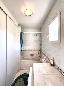 ein Badezimmer mit Badewanne, Dusche und Waschbecken in der Unterkunft Maison Marina Pietra avec Jardin in Pietracorbara + 14 Fotos