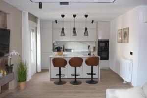 a kitchen with a counter and two bar stools at Apartamentos La Herradura Toneles in Haro