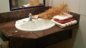 a bathroom sink with towels on a counter at Alojamientos La Dehesa in El Berrueco