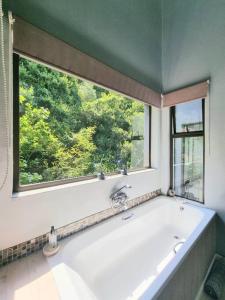 a bath tub in a bathroom with a window at Sea La Vie Beach House in Wilderness