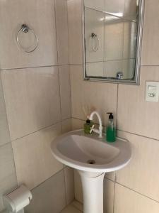 a bathroom with a white sink and a mirror at Quarto 03 in Sinop