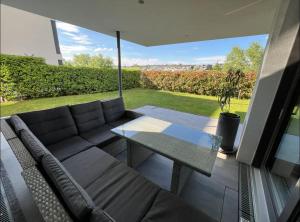 a living room with a couch and a glass table at Studio Apartment direkt am Phoenixsee in Dortmund