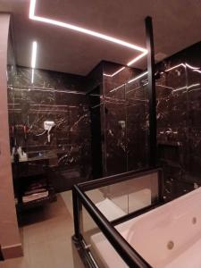 a bathroom with a tub and a black wall at Motel Marselha 5 in Sao Paulo