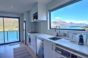 a kitchen with a sink and a large window at Relax on Snowy Place in Queenstown