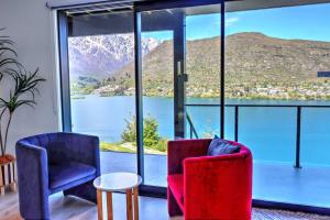 two chairs and a table in front of a large window at Relax on Snowy Place in Queenstown