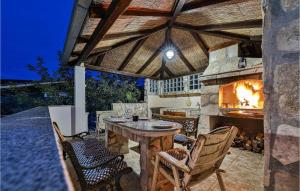a patio with a table and a stone fireplace at Two-Bedroom Holiday Home In Drvenik Veli in Veliki Drvenik