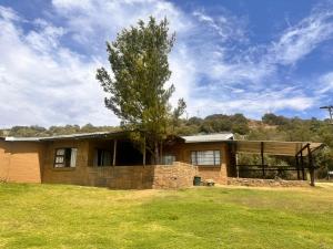 a house with a tree in front of it at Farm stay at Lavender Cottage on Haldon Estate in Bloemfontein