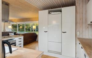 a kitchen with white cabinets and a living room at Amazing Home In Nykøbing Sj With Wifi in Nykøbing Sjælland +17 photos