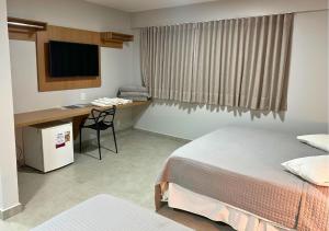 a hotel room with a bed and a desk and a television at Brasília Park Hotel in Brasilia +32 photos