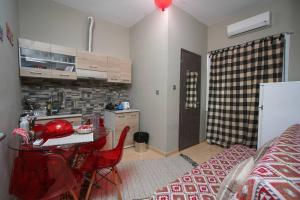 a kitchen with a table and red chairs in a room at C i t y v i b e s Διαμέρισμα Α1 in Ioannina