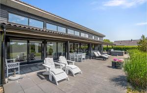 eine Terrasse mit weißen Stühlen, Tischen und Fenstern in der Unterkunft Holiday Home Hemmet With Fireplace 03 in Hemmet + 17 Fotos