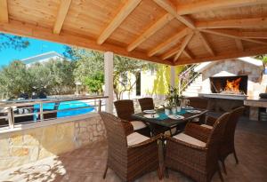 a patio with a table and chairs and a fireplace at Villa Marin in Trogir