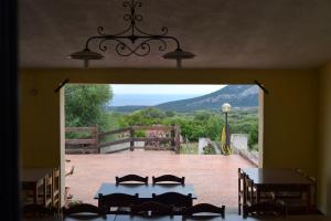 an open door to a patio with tables and chairs at Agriturismo Paulesa in Cala Gonone