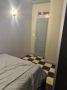 a bedroom with a bed and a door with a checkered floor at Maison de vacances in Conilhac-Corbières