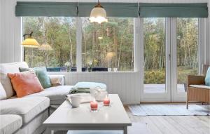a living room with a couch and a table at Holiday Home Gubbegårdsvejen Nexø Vi in Bedegård