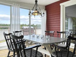 a dining room with a table and chairs on a porch at 6 person holiday home in VALDERMARSVIK in Stora Getterö