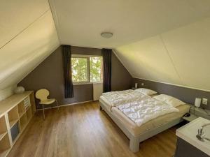 a bedroom with a bed and a sink and a window at Familiehuis Zeegserduinen in Zeegse