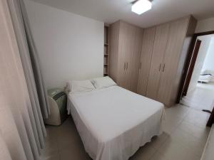 ein kleines Schlafzimmer mit einem weißen Bett und Schränken in der Unterkunft Cittá Por do sol Familia Shopping e Parque in Brasilia