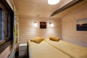 Un dormitorio con una cama en una habitación de madera. en Riekonsoppi, two bedroom private cabin, en Pyhätunturi 24 fotos más