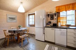 a kitchen with a table and a refrigerator at Riekonsoppi, two bedroom private cabin in Pyhätunturi +32 photos