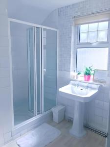 a white bathroom with a sink and a shower at Hollybush Guest House in Oxford +59 photos