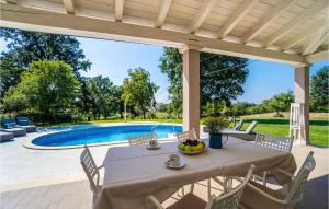 a patio with a table and chairs and a pool at Villa Miana in Orbanići