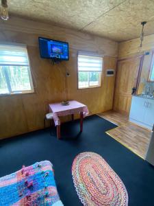 a room with a table and a tv on the wall at Cabaña la chilotita in Dalcahue