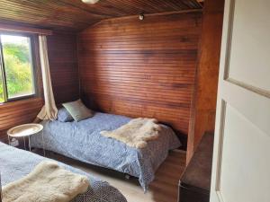 a bedroom with two beds in a wooden wall at Casa frente al mar in El Quisco
