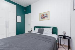 a bedroom with a bed with a green headboard at Mano jūra Small rest house in Palanga +31 photos