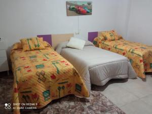 a bedroom with two beds and a bedspread with a car on it at Casa en la huerta - Villa Encarna in Caravaca de la Cruz